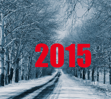 Text red numbers 2015 on a background of a winter forest and the roadの写真素材