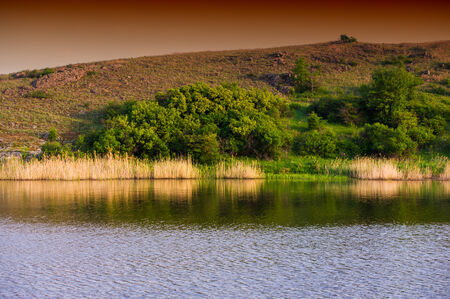 spring rural landscape, river field and cloudsの写真素材