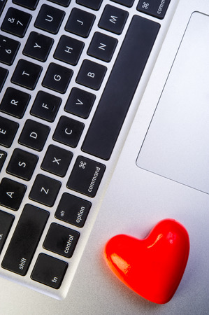 one heart valentine lies on the laptopの写真素材