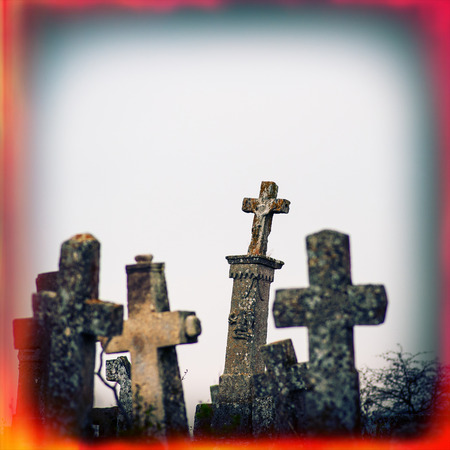 Old terrible stone cross on cemetery on background of sky, autumn season