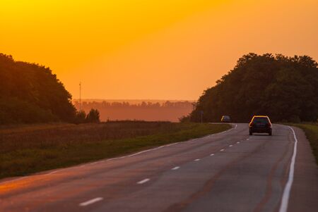 landscape, road and cars at sunsetの写真素材
