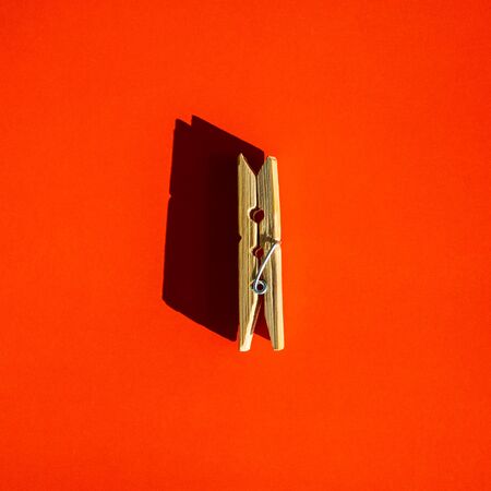 one clothespin lies on an orange backgroundの写真素材