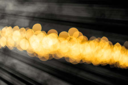 blurred spots and golden white light on a dark backgroundの写真素材