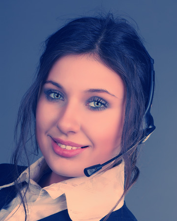 portrait of a beautiful business woman in headphones with a microphoneの写真素材