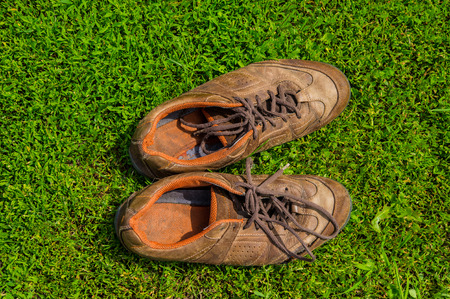 old sports shoes on a background of green grassの写真素材