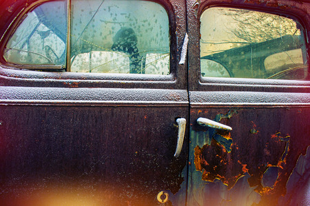 door old abandoned car covered with snowの写真素材