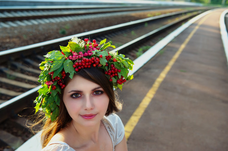 portrait of a girl with a wreath on his head against the background of the railwayの写真素材