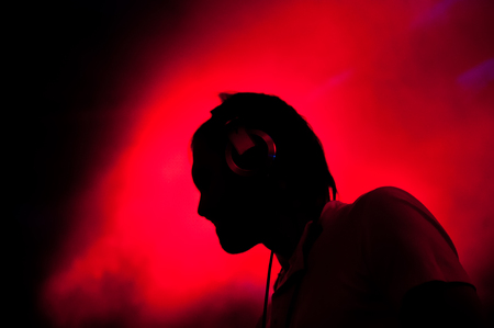 DJ performs at night disco, blurred backgroundの写真素材