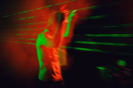 DJ performs at night disco, blurred backgroundの写真素材