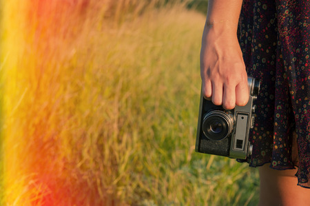 girl holding a film camera in nature