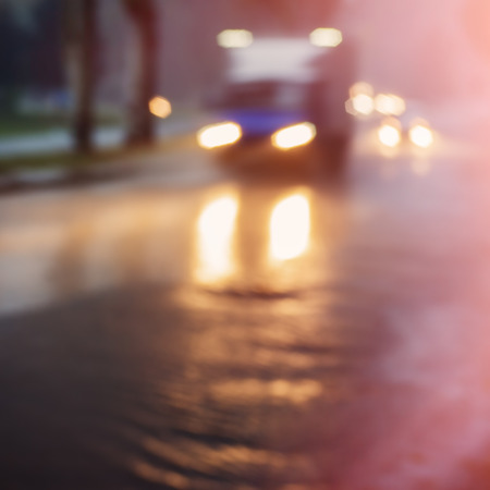 truck driving in the city at night in the rain, blurred background