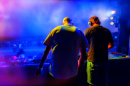 DJs perform in a night disco, blurred background