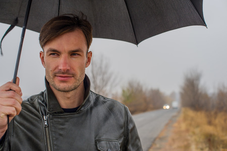 Businessman with an umbrella outdoors