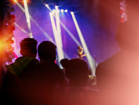audience at the concert, blurred dark background