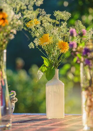 Vase and bouquet of summer flowers on a table in the gardenの写真素材