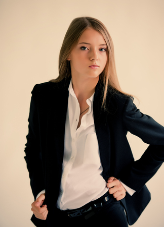 Girl in a dark suit on a light background portraitの写真素材