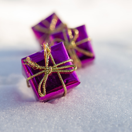 Christmas toy gift box lies on the snow in the sunlight
