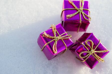 Christmas toy gift box lies on the snow in the sunlightの写真素材