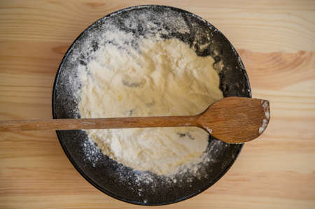 wooden spoon lies on a plate with flour, cookingの写真素材