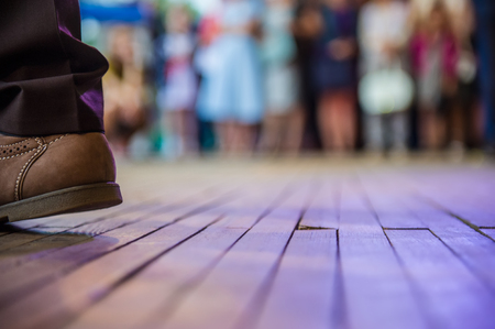 men's foot in the shoes and dance floor in the open areaの写真素材