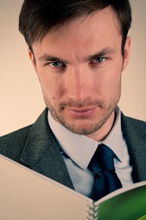 Businessman is Looking at a Text in a Notebook. Portrait Businessman. Man Looking. Closeup.の写真素材