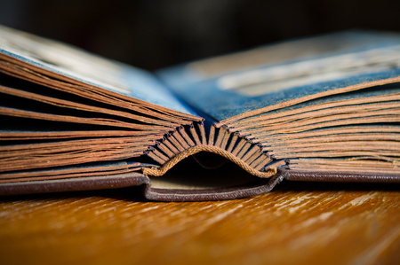 pages of an open old photo album on the table in the room. Old book. Retro. Closeup.の写真素材