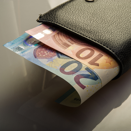paper euro notes and an old wallet. Twenty and ten euros. Currency of the European Union.