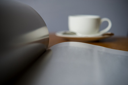 Open magazine with a cup of coffee on the desk in the office.