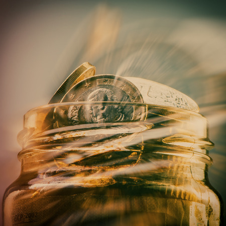 group of coins one euro in a glass jar. Euro money. Blurred background. Currency of the European Union.の写真素材