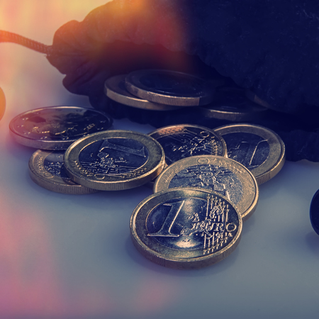 coins one euro and a black bag with money. Closeup. Currency of the Euro Union.の写真素材