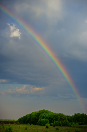 rainbow on a background of clouds and landscape. Spring season.の写真素材