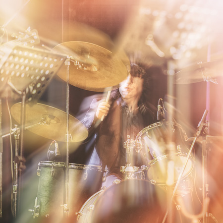 Drum set, music and jazz band concept. A musician playing with chopsticks on percussion instruments. Blurred background.の写真素材