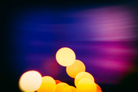 Abstract blurred background. Multicolored light spots on a dark background.