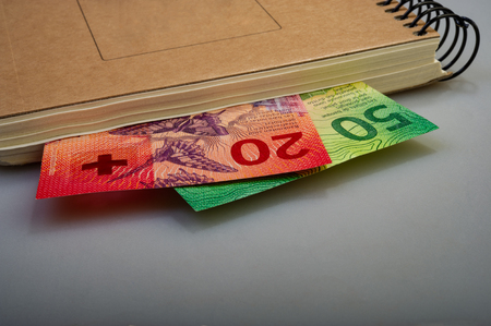 Swiss banknotes are fifty, ten, twenty francs and a notepad. Cash.の写真素材