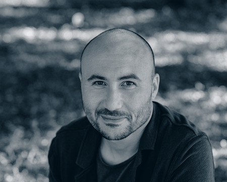 face of a bearded smiling bald man in the park. Portrait of a middle-aged man.