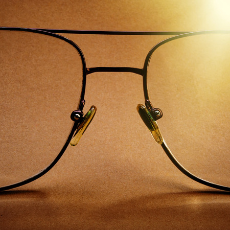 Eyeglass frame on a brown background monochrome, closeup.  Promotion, Marketing, SMM, CEO, Businessの写真素材