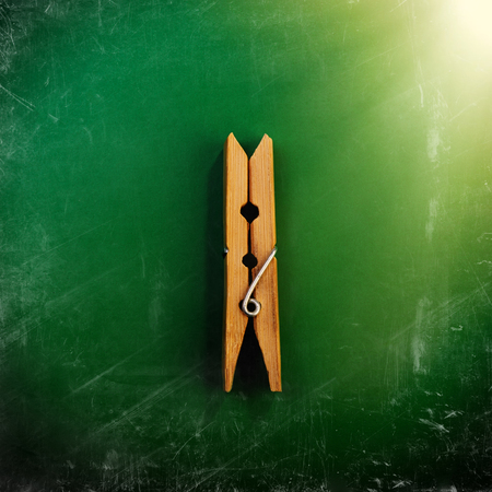 One Wooden Clothespin on a Green Background, Scratches and Scrapes. Promotion, Marketing, SMM, CEO, Businessの写真素材