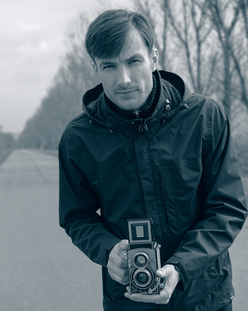 traveling photographer takes a picture of the landscape in the countryside. Early spring, March.