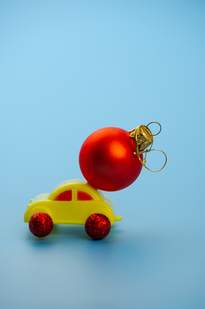 toy car carries a Christmas tree red ball. Web design. For the blog.の写真素材