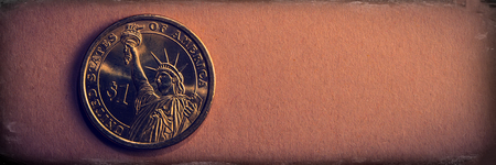 One dollar coin lies on a brown paper background. Coin of the USA. Web banner.の写真素材