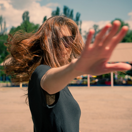 Portrait of a girl making a forbidding hand gesture.