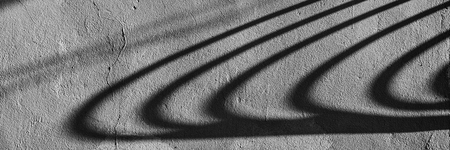 Symmetrical dark shadows on the surface of the wall on a sunny day. Web banner for design.の写真素材