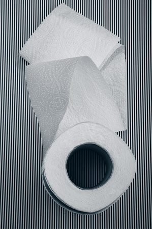 unfolded roll of toilet paper on a striped background.の写真素材
