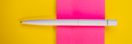 White pen and pink sticker lie on a yellow background. Web banner.の写真素材