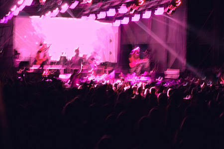 night show with the participation of a rock music band in the open air, blurred background.