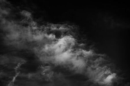 white clouds against a dark sky. Summer season, august. Monochrome photo.の写真素材