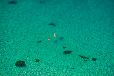 CRIMEA, UKRAINE- August 2010: couple of people swimming in the sea on a sunny day in shallow water. Summer season, august. Black Sea.のeditorial素材
