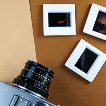 film camera and slides in the frames lie on a cream and brown background. Cover. Web banner. Element for design.の写真素材