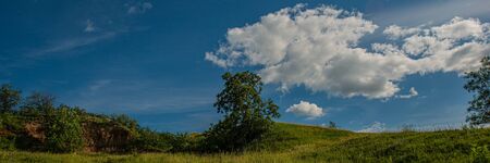 Sky and clouds over a meadow on a hillside on a sunny day. Summer season. Web banner. Ukraine....