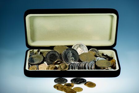 Swiss coins and francs are in an open box against a blue background. Business concept. Web banner.の写真素材